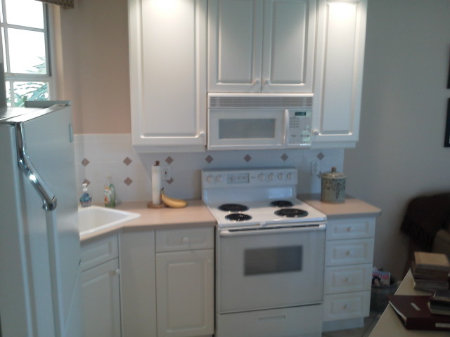 Before cabinet refacing, white cabinets, stove surround