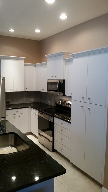 A before picture of plain white cabinets refaced by Kitchen Facelifts
