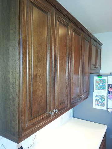 Above the counter cabinets refaced with a dark wood finish by Kitchen Facelifts in Southwest Florida